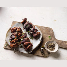 Load image into Gallery viewer, Five Vegans Fable pulled shiitake mushroom skewers served on a rustic ceramic plate with herbs and seasoning